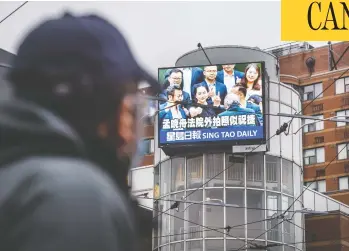  ?? PETER J THOMPSON / NATIONAL POST ?? A pedestrian walks past digital signage for the newspaper Sing Tao Daily in Toronto on Friday. Some inside Chinese
language media in Canada worry coverage of events is affected by a desire not to offend the government in China.
