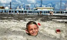  ??  ?? Jacob Seigfried, 10, of Wichita Falls, enjoyed the Memorial Day weekend by getting buried in the sand off Pleasure Pier.