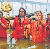  ?? ?? Maha Mandaleshw­ar (UP) of Kinnar Akhada Swami Kaushaliya­nand Giri aka Tina Ma along with her disciples and members of the trans community taking a dip in Ganga on Paush Purnima at Ram Ghat in tent city on Monday.