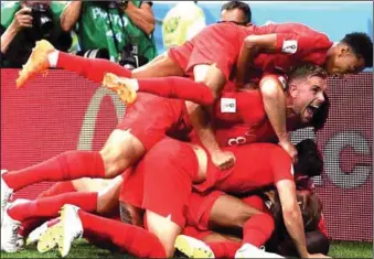  ??  ?? England’s match-winner Harry Kane is mobbed by his team-mates after scoring his side’s dramatic winner against Tunisia