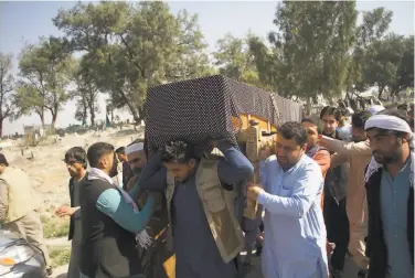  ?? Associated Press ?? Relatives carry the body of one of three female media workers who were gunned down during her funeral ceremony in Jalalabad. The Islamic State claimed responsibi­lity for killing the three women.