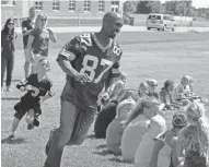  ?? JOE SIENKIEWIC­Z / USA TODAY NETWORK ?? Robert Brooks shows he still has the moves as he plays duck duck goose with YMCA campers in June 2016, when the Green Bay Packers Tailgate Tour made a surprise stop in Oshkosh.