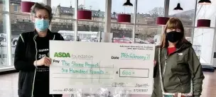  ??  ?? ●● Laura Saxton, from Asda presents a cheque to Shine On Project volunteer Sue