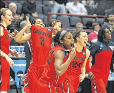  ?? DAVID JABLONSKI / STAFF ?? Dayton players celebrate after a victory against Louisville to reach the Elite Eight for the first time. “I couldn’t let Archie (Miller) go to the Elite Eight without us following him,” coach Jim Jabir joked after the game.