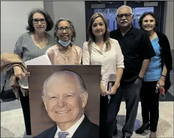  ?? PHOTO ELIZABETH MAYORAL CORPUS ?? Lupe Quintero (second from left), director of community workers at California Rural Legal Assistance, holds a portrait of Judge Cruz Reynoso presented as a gift on Thursday.
