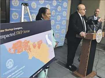  ?? Wally Skalij Los Angeles Times ?? ADEL HAGEKHALIL, general manager of the Metropolit­an Water District of Southern California, outlines new water restrictio­ns at a news conference. He’s flanked by MWD officials Gloria Gray and Deven Upadhyay.