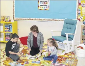  ?? LYNN CURWIN/TRURO DAILY NEWS ?? Teacher Pauline Mackinnon, looks through some of the books in the K4-K5 classroom with students Owen Mcleod and Madelyn Miller. The room has been completely redecorate­d, thanks to many volunteer hours.