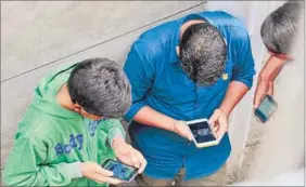  ?? WASEEM ANDRABI/ HT ?? Youngsters surf the internet on their phones after hacking into a Wi-fi network in Srinagar as mobile internet remains suspended in the conflict-hit Kashmir.