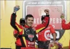  ?? CARLOS OSORIO — THE ASSOCIATED PRESS ?? Kyle Larson raises his arms upon exiting his car after winning Sunday’s NASCAR Monster Energy Cup series in Brooklyn, Mich. race