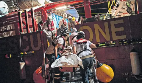  ??  ?? Aquarius rescue ship crew members prepare to load the body of a migrant who died at sea onto a small vessel; Adam, left, told rescuers of torture at the hands of Libya’s militias