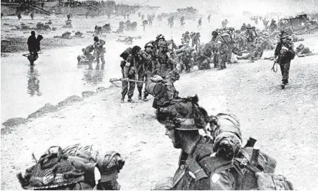  ?? Associated Press ?? Troops move on shore from their landing craft during the D-Day invasion of German-occupied France during World War II.