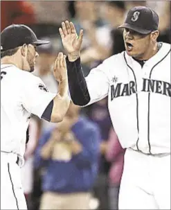  ?? Photo by Getty ?? Casper Wells (l.) and Felix Hernandez celebrate the Mariners’ five-hitter over Red Sox.