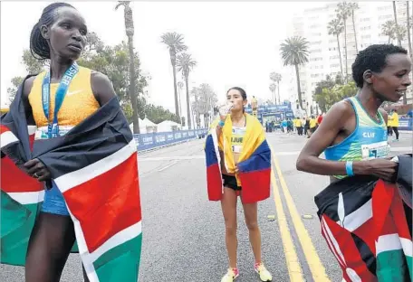  ?? Photograph­s by Genaro Molina Los Angeles Times ?? HELLEN JEPKURGAT of Kenya, from left, winner of the women’s division of the L. A. Marathon, stands with Angela Orjuela of Colombia, who finished third, and Jane Kibii of Kenya, who finished second. Jepkurgat finished almost two minutes ahead of Kibii.