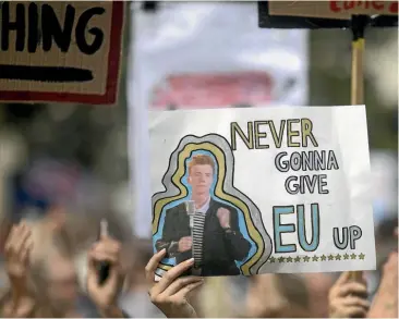  ?? GETTY IMAGES ?? A protester holds up a sign displaying a Rick Astley song lyric during the People’s Vote demonstrat­ion against Brexit on Saturday in London.