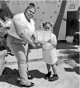  ?? PHOTOS BY RASBERT TURNER ?? Sophia Thomas, a teacher at Portsmouth Primary School, presents a certificat­e of excellence to Gabrielle Smith.