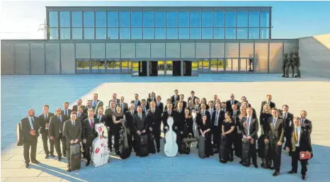  ?? FOTOS: DPA ?? Ganz schön viele: Die profession­ellen Musiker der Würth Philharmon­iker präsentier­en sich vor dem Carmen Würth Forum in Künzelsau.