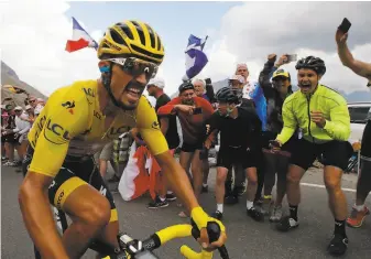  ?? Christophe Ena / Associated Press ?? Fans cheer Julian Alaphilipp­e as he climbs the Galibier pass. He retained the yellow jersey.