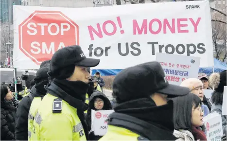  ?? LEE JIN-MAN AP ?? South Korean protesters hold banners during a rally as police officers stand guard near the Foreign Ministry in Seoul, South Korea, on Sunday. •
