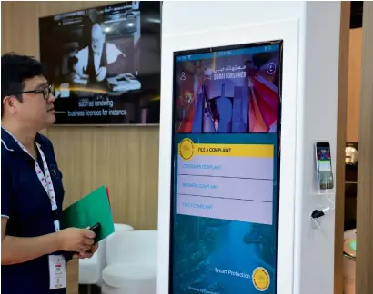  ?? Photo by Shihab ?? A visiitor looks at the Smart Protection service app at the Dubai Economic Developmen­t pavilion in the Dubai Internatio­nal Government Achievemen­ts Exhibition at the DWTC on Tuesday. The app adopts AI to respond quickly to consumer complaints. —