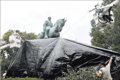  ?? Steve Helber ?? The Associated Press City workers drape a tarp Wednesday over the statue of Robert E. Lee in Emancipati­on Park in Charlottes­ville, Va.