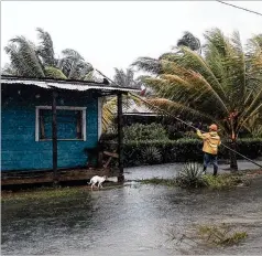  ?? CARLOS HERRERA/AP ?? A man fixes the roof of a home in by floodwater­s brought on by Hurricane Eta in Wawa, Nicaragua, on Tuesday. Rains from what was a Category 4 storm at its peak were causing rivers to overflow across Central America.