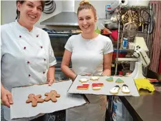  ?? Foto: Katharina Heimeier/dpa ?? Die Café Besitzerin Anke Rhönisch (links) und Auszubilde­nde Melina Papadaki zeigen ihre fertig verzierten Weihnachts­plätzchen.