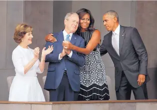  ?? PABLO MARTINEZ MONSIVAIS/ASSOCIATED PRESS ?? First lady Michelle Obama hugs former President George W. Bush, as President Barack Obama and former first lady Laura Bush walk on stage at the museum dedication ceremony.