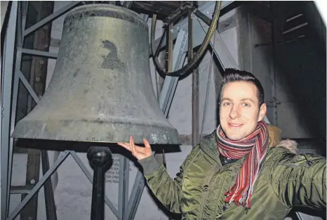  ?? FOTO: SCHOLZ ?? Im Merklinger Kirchturm: Pfarrer Cornelius Küttner zeigt, wie groß eine der insgesamt fünf Glocken ist.