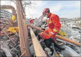  ?? REUTERS ?? ▪ A rescue worker rummages through the site of the blast.