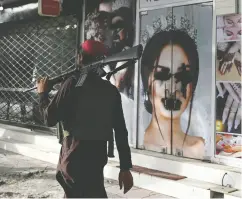  ?? WAKIL KOHSAR / AFP VIA GETTY IMAGES ?? A Taliban fighter walks past a defaced beauty salon.
America’s quick exit from Afghanista­n has already emboldened other terrorist groups, Avi Benolo writes.