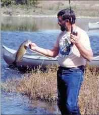  ?? KEITH SUTTON/CONTRIBUTI­NG PHOTOGRAPH­ER ?? Jim Spencer of Calico Rock lands a nice smallmouth bass on a float trip on the Ouachita River. Canoes provide the ideal means for fishing many of Arkansas’ small mountain streams.