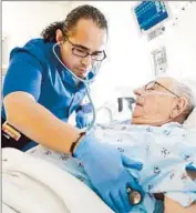  ?? Mel Melcon Los Angeles Times ?? DAVID FUENTES, one of a growing number of men in the nursing profession, examines Russell Sherman, 87. “It doesn’t faze me at all,” Sherman says.