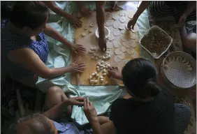  ?? JESSIE WARDARSKI — THE ASSOCIATED PRESS ?? People prepare dozens of momos, traditiona­l Tibetan steamed dumplings, in the garage of a home July 19 in Columbia Heights, Minn.