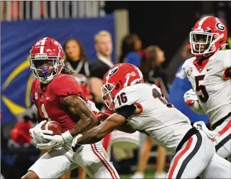  ?? HYOSUB SHIN/HYOSUB.SHIN@AJC.COM ?? Alabama wide receiver Jameson Williams makes a touchdown catch over Georgia defensive back Lewis Cine (16) during the SEC Championsh­ip, one of his two in the game.