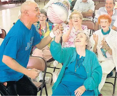 ?? JOHN RAOUX/ORLANDO SENTINEL ?? Former Harlem Globetrott­er and Magic community ambassador Curly Neal teaches Margaret Kapanke how to spin a basketball during a 1998 visit to the Marks Street Senior Recreation Complex in Orlando.