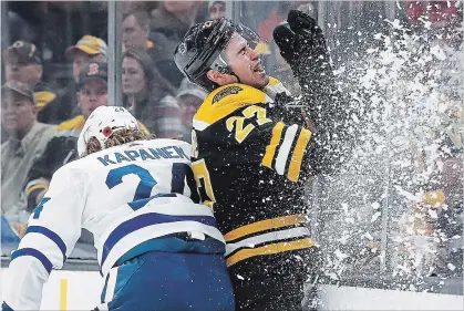  ?? WINSLOW TOWNSON
THE ASSOCIATED PRESS ?? Toronto’s Kasperi Kapanen, left, checks Boston’s John Moore into the boards in the Bruins’ 5-1 win over the Maple Leafs on Saturday night.