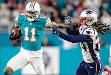  ?? ALLEN EYESTONE / THE PALM BEACH POST ?? Dolphins wide receiver DeVante Parker (left) stiff-arms Patriots cornerback Stephon Gilmore after making a catch. After three seasons, the former first-round draft pick hasn’t met expectatio­ns.