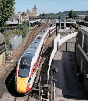  ?? PAUL SHANNON. ?? A Class 800 eases out of Lincoln station and across High Street level crossing with an LNER service to London King’s Cross on June 25, while an East Midlands Railway Class 158 and a Northern ‘195’ prepare to depart with services for Leicester and Sheffield. The 2% profit margin c Exclusive urrently allowed to operators under Emergency Measures Agreements could be significan­tly cut by government following the expiry of the EMAs in September.