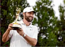  ?? Jared C. Tilton/getty Images ?? Scottie Scheffler celebrates with the trophy after winning The Players Championsh­ip on Sunday in Ponte Vedra Beach, Fla.