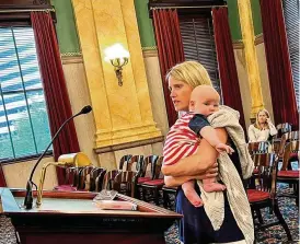  ?? LAURA HANCOCK / CLEVELAND.COM ?? Erin Merryn testified Tuesday before the Ohio Senate Primary and Secondary Education Committee. She is holding her three-month-old son, Jack. On the podium is a pink childhood diary where she wrote about being sexually abused, because she was afraid to tell any safe adults.