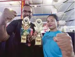  ??  ?? AZMI (kiri) dan Yong IIyani Farziha bersama trofi yang dimenangi dalam Kejohanan Pusaka Ultimate Fight 2017 di Kompleks Bukit Jambul, Pulau Pinang.