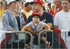  ?? (Reuters) ?? A CHILD AND HIS FATHER wait eagerly to hear Republican candidate Donald Trump speak in Des Moines, Iowa, on Saturday.