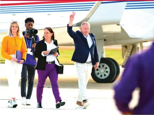  ?? MATTHEW HINTON/AP ?? New LSU coach Brian Kelly gestures to fans after his arrival Tuesday at Baton Rouge Metropolit­an Airport. He will be introduced at a news conference Wednesday.