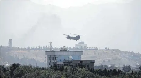  ?? FOTO: RAHMAT GUL/DPA ?? Ein Hubschraub­er von Typ Chinook fliegt über der US-Botschaft in Kabul: Die Bemühungen der Regierung Biden konzentrie­ren sich darauf, das Botschafts­personal in Sicherheit zu bringen.