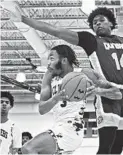  ?? KENNETH K. LAM/BALTIMORE SUN ?? Half:
Patterson senior guard John Thomas, driving toward the basket against Dunbar’s Tony Hart, right, in the third quarter Monday, had 21 points to lead the No. 12 Clippers to a 60-39 victory.
