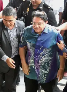  ??  ?? Facing the law: Tengku Adnan being led to the Sessions Court in Kuala Lumpur.
