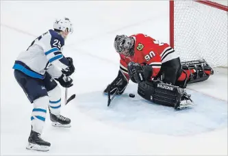  ?? KAMIL KRZACZYNSK­I
THE ASSOCIATED PRESS ?? Blackhawks goalie Scott Foster makes a save against Winnipeg centre Paul Stastny Thursday in Chicago.