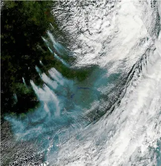  ?? AP ?? A natural-colour image acquired by the Moderate Resolution Imaging Spectrorad­iometer on the Aqua satellite and provided by Nasa, shows thick plumes of smoke, left centre, rising from dozens of large forest fires in north-central Russia.