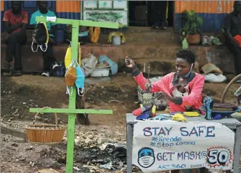  ?? TONY KARUMBA / AFP ?? A local artist makes and sells face masks made from cloth in the Nairobi, Kenya, on April 14. Kenya has so far cordoned off the capital and parts of its coastline and imposed a nighttime curfew and other social distancing measures in it’s bid to curb the spread of the coronaviru­s.