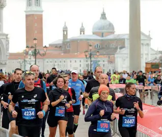  ??  ?? Passione solidale La folla di concorrent­i nello splendido scenario della Venicemara­thon